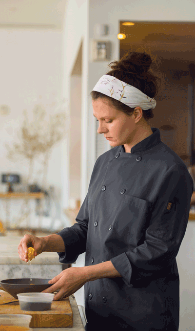 chef garnishing a dish in a kitchen